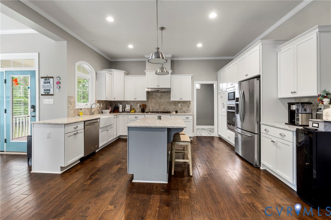 16507 Hannington Drive Midlothian, VA 23112 - Photo 15 of 43 a kitchen with stainless steel appliances kitchen island granite countertop a refrigerator a stove top oven a sink dishwasher and a dining table with wooden floor