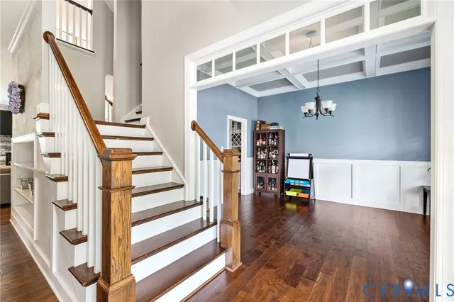 a view of staircase with lots of frames on wall and wooden floor