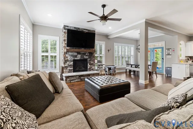 a living room with furniture a flat screen tv and a large window