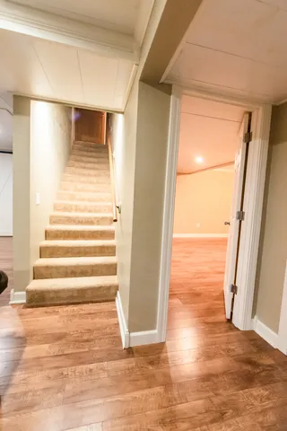 a spacious bedroom with a bed and dresser with wooden floor