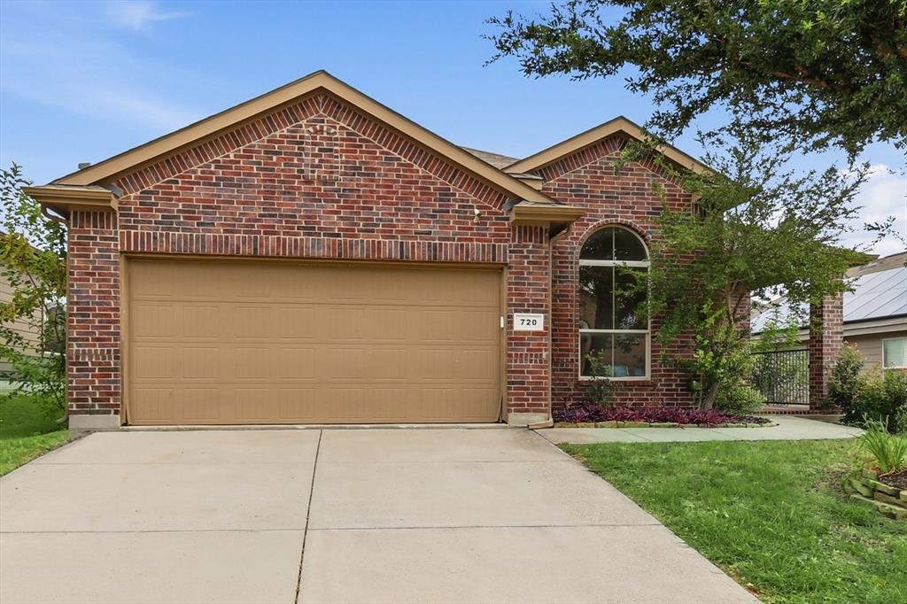 720 Rio Bravo Drive Fort Worth, TX 76052 - Photo 1 of 38 Brick facade home featuring a two-car garage, an arched window, and a concrete driveway
