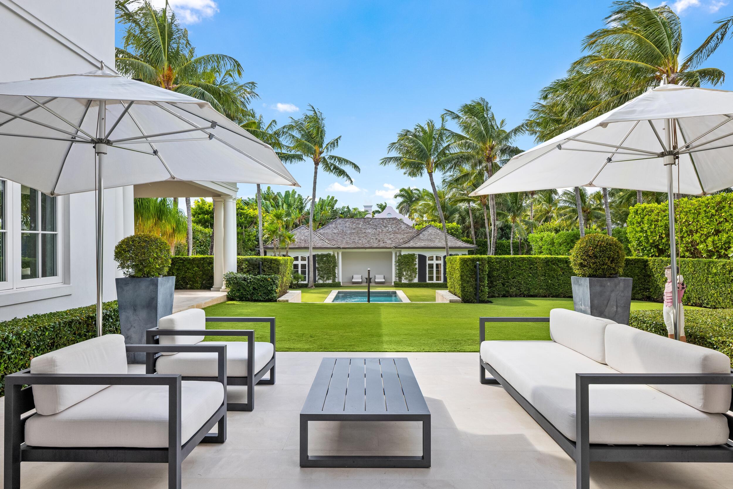102 Reef Road Palm Beach, FL 33480 - Photo 17 of 22 a view of a patio with a table and chairs under an umbrella