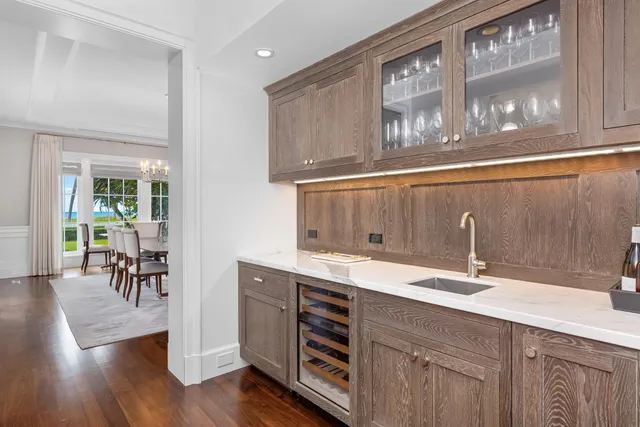 a sink with white cabinets and wooden floor