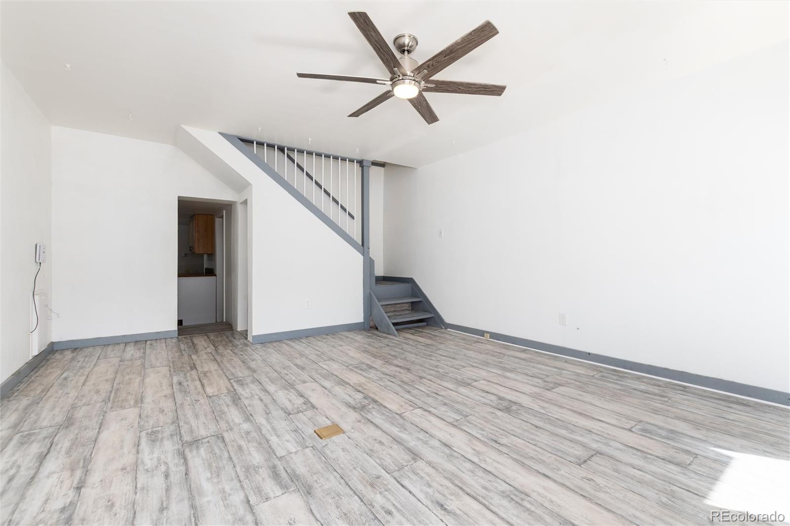 735 Colorado Boulevard Idaho Springs, CO 80452 - Photo 17 of 34 an empty room with wooden floor ceiling fan and windows