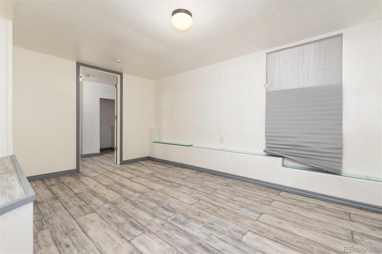 735 Colorado Boulevard Idaho Springs, CO 80452 - Photo 21 of 34 an empty room with wooden floor and windows
