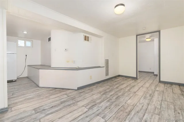 a view of a kitchen with wooden floor and electronic appliances