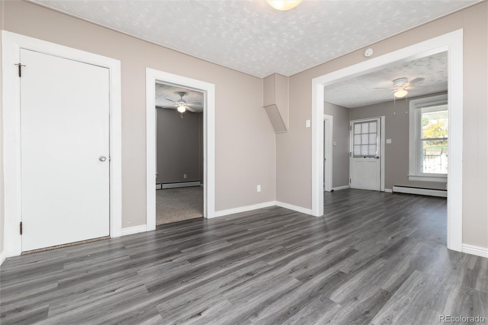 735 Colorado Boulevard Idaho Springs, CO 80452 - Photo 4 of 34 an empty room with wooden floor and windows