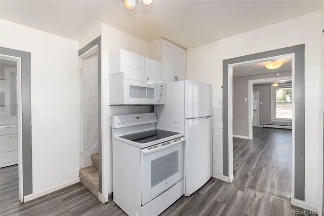 a kitchen with white cabinets and white appliances
