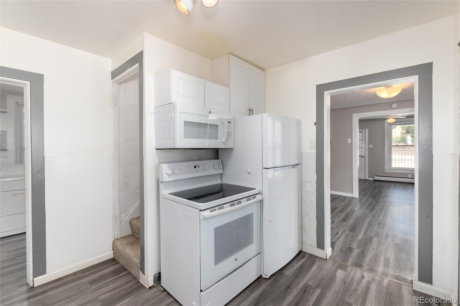 735 Colorado Boulevard Idaho Springs, CO 80452 - Photo 6 of 34 a kitchen with white cabinets and white appliances