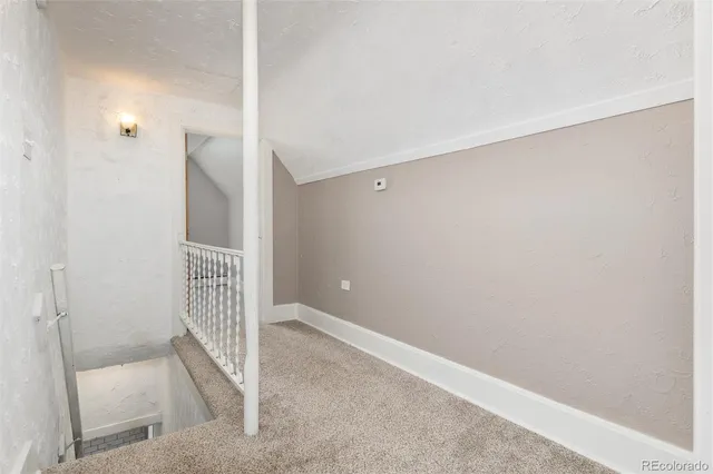 an empty room with windows and chandelier fan