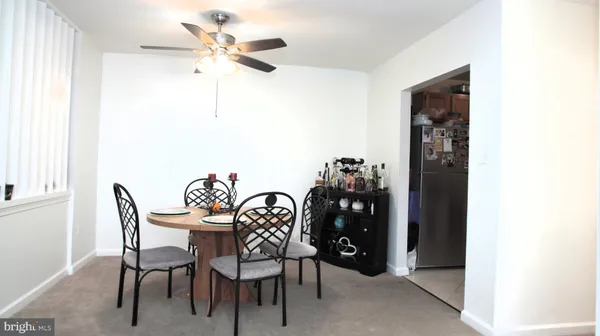 a dining room with furniture and chandelier fan