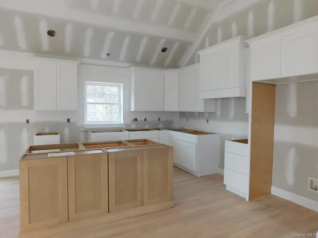 a kitchen with stainless steel appliances a sink a stove a refrigerator cabinets and a window