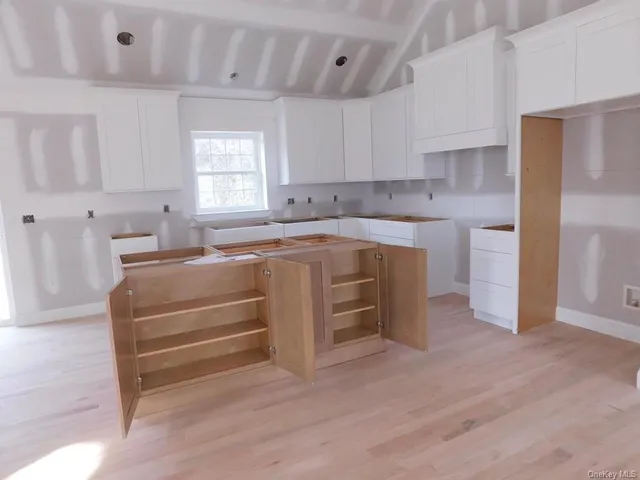 a kitchen with kitchen island sink and cabinets
