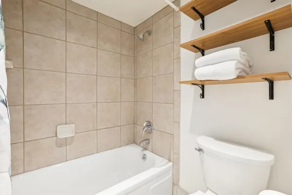 a white bath tub sitting next to a white toilet and sink
