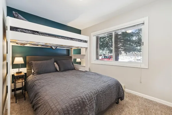 a bed sitting in a bedroom next to a window