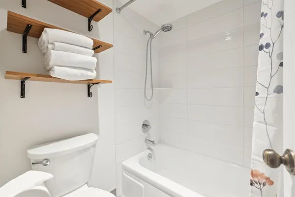 a white bath tub sitting next to a white toilet