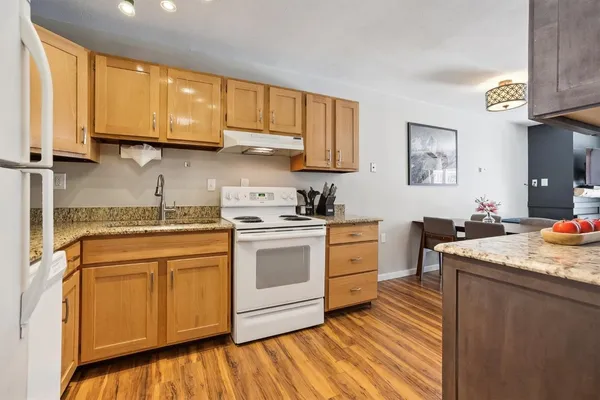 a kitchen with stainless steel appliances granite countertop a sink stove and cabinets