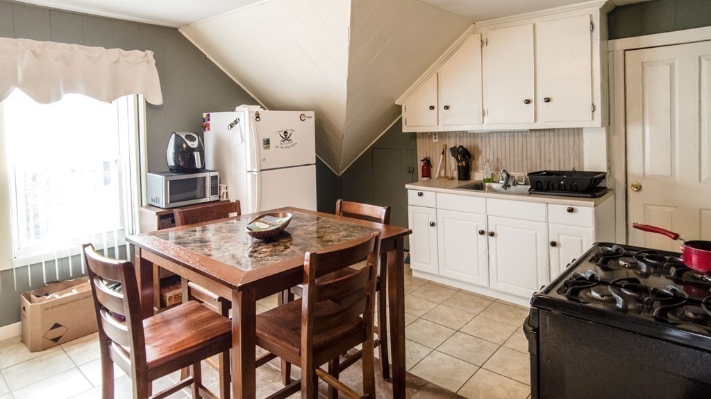 1141 Stafford Road Fall River, MA 02721 - Photo 19 of 30 a kitchen with stainless steel appliances kitchen island a table chairs and a refrigerator