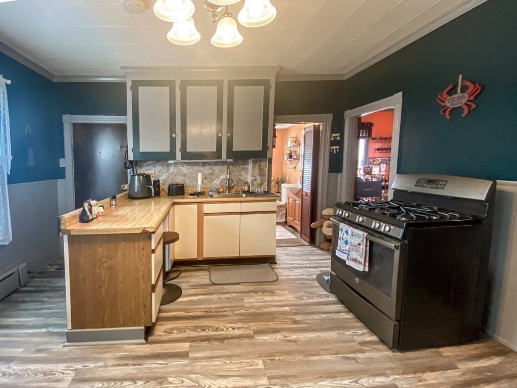 1141 Stafford Road Fall River, MA 02721 - Photo 5 of 30 a kitchen with a stove sink and cabinets
