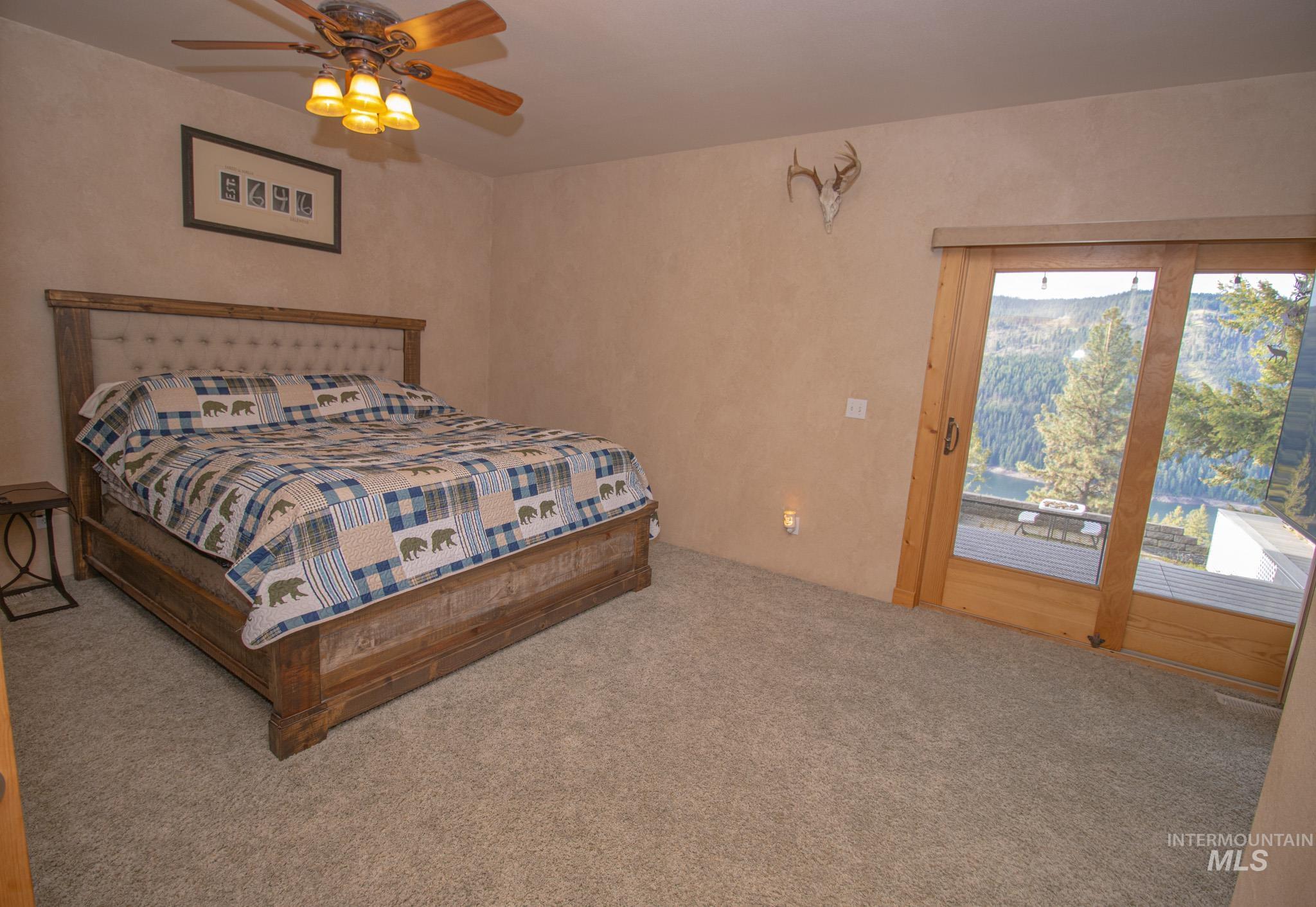 237 Old Dent Road Orofino, ID 83544 - Photo 17 of 48 Bedroom featuring access to outside, carpet, and ceiling fan
