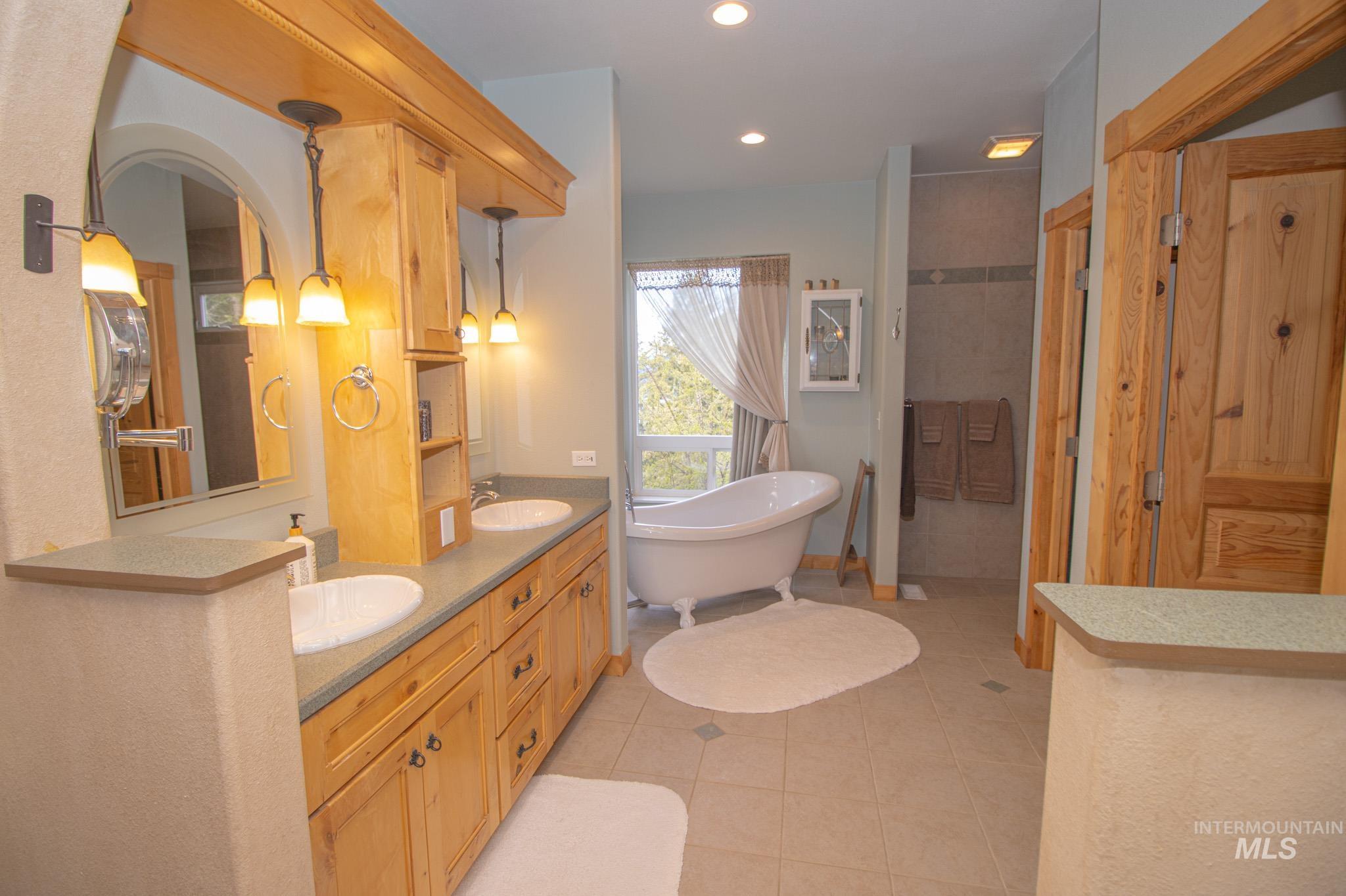 237 Old Dent Road Orofino, ID 83544 - Photo 19 of 48 Bathroom featuring double vanity, light tile patterned floors, a freestanding tub, recessed lighting, and a walk in shower
