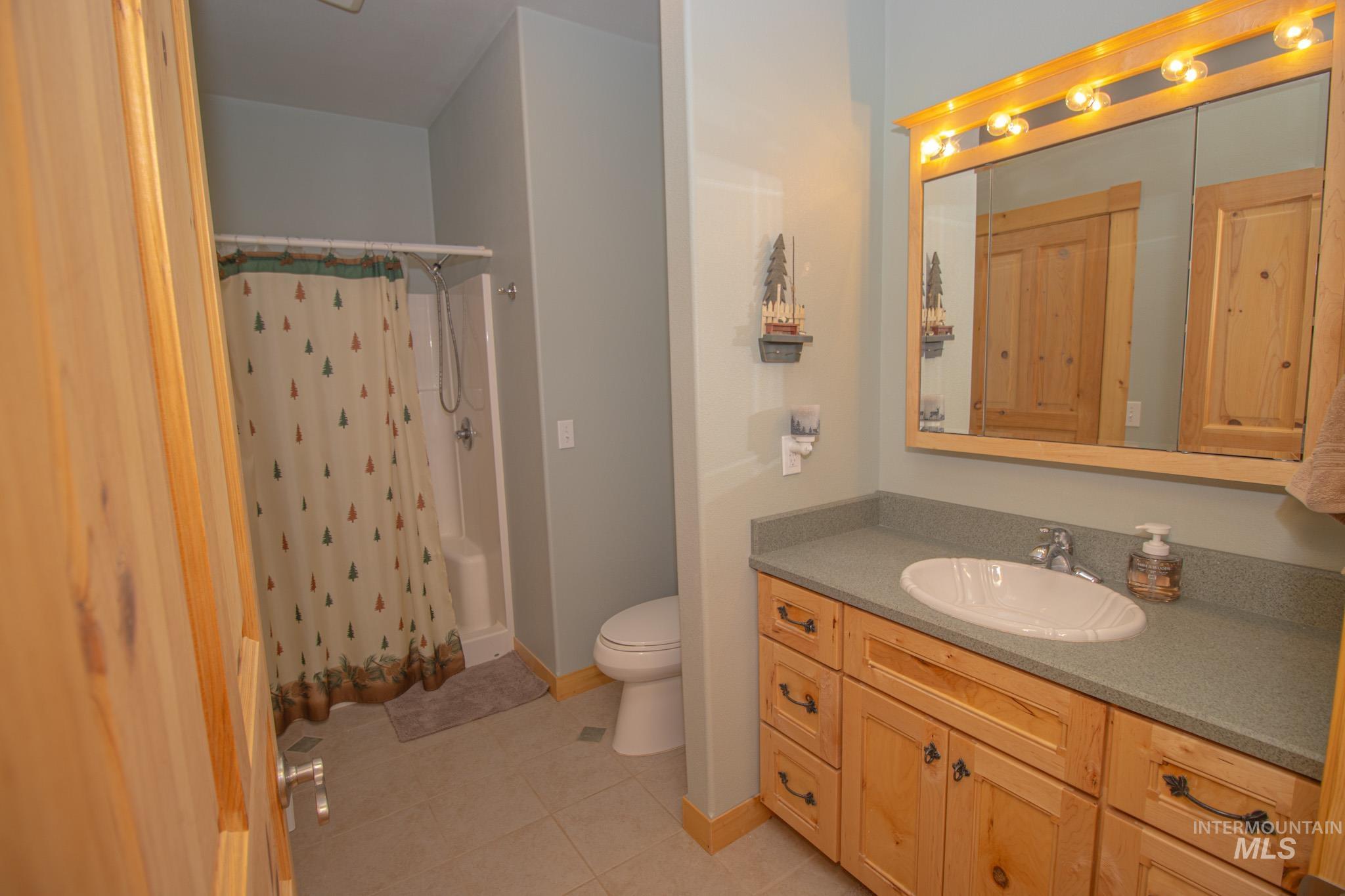 237 Old Dent Road Orofino, ID 83544 - Photo 24 of 48 Bathroom featuring vanity, light tile patterned flooring, and shower / tub combo with curtain