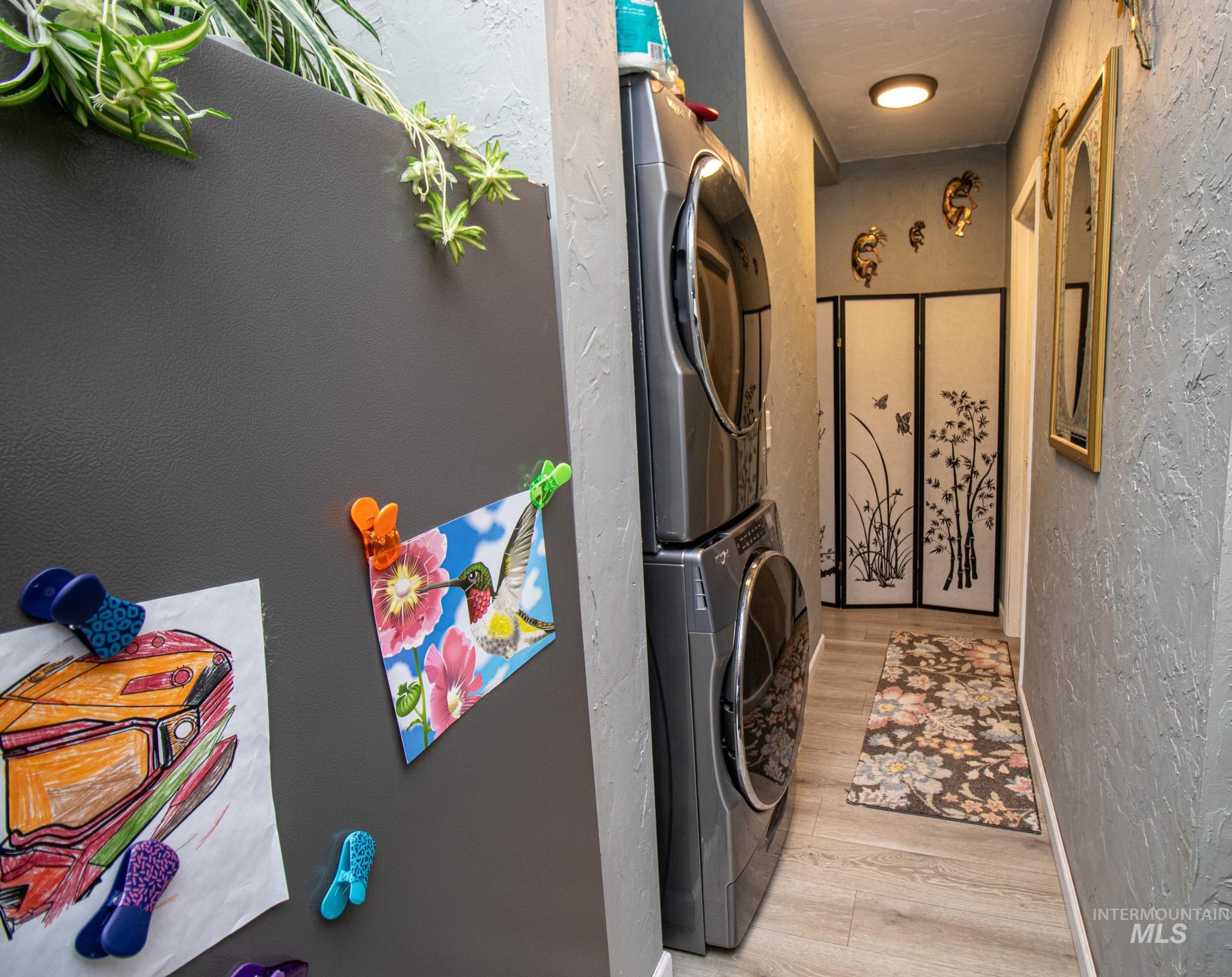 237 Old Dent Road Orofino, ID 83544 - Photo 36 of 48 Laundry area with a textured wall, stacked washer / dryer, and light wood-style flooring