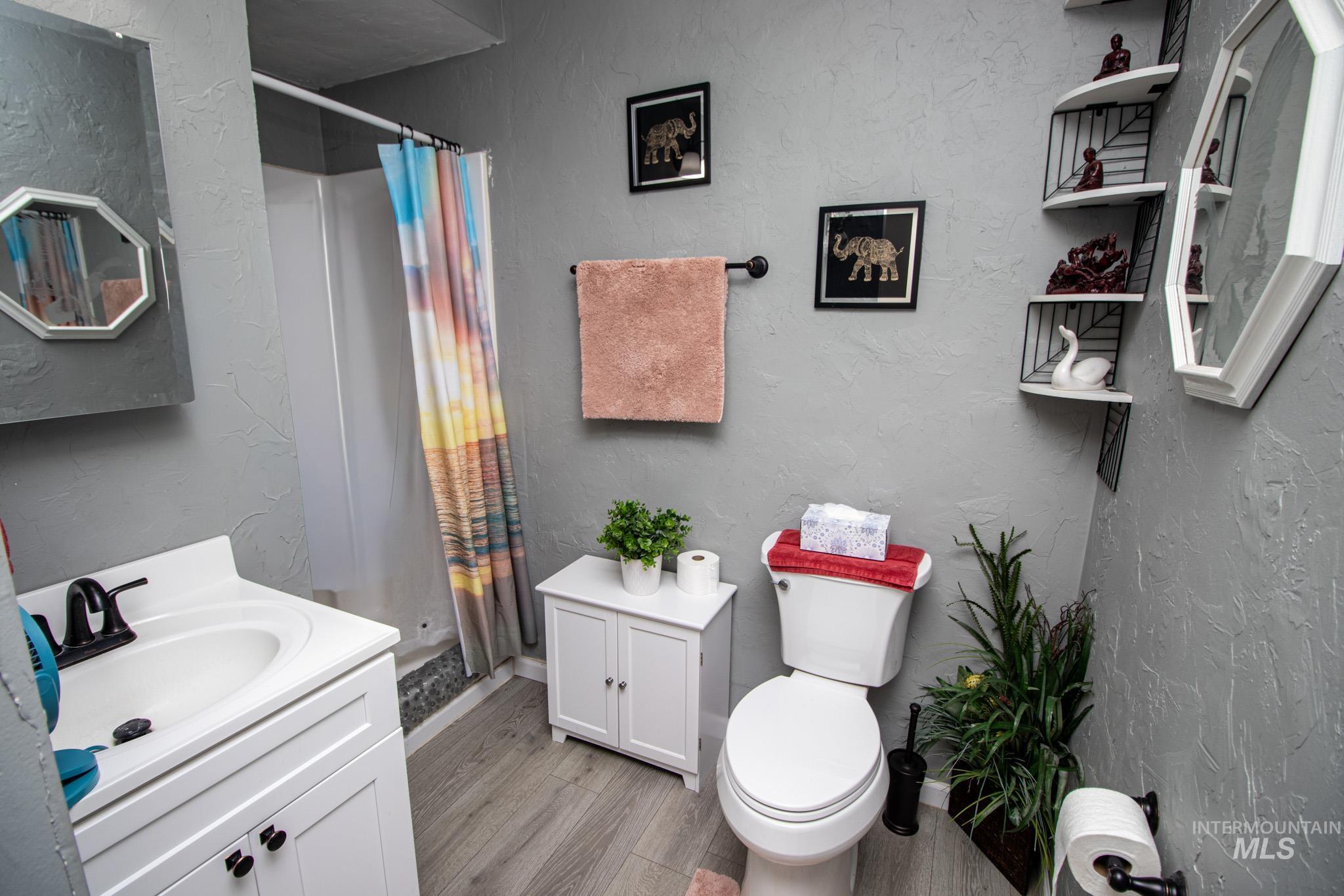 237 Old Dent Road Orofino, ID 83544 - Photo 37 of 48 Bathroom featuring a textured wall, vanity, a shower stall, and light wood-type flooring