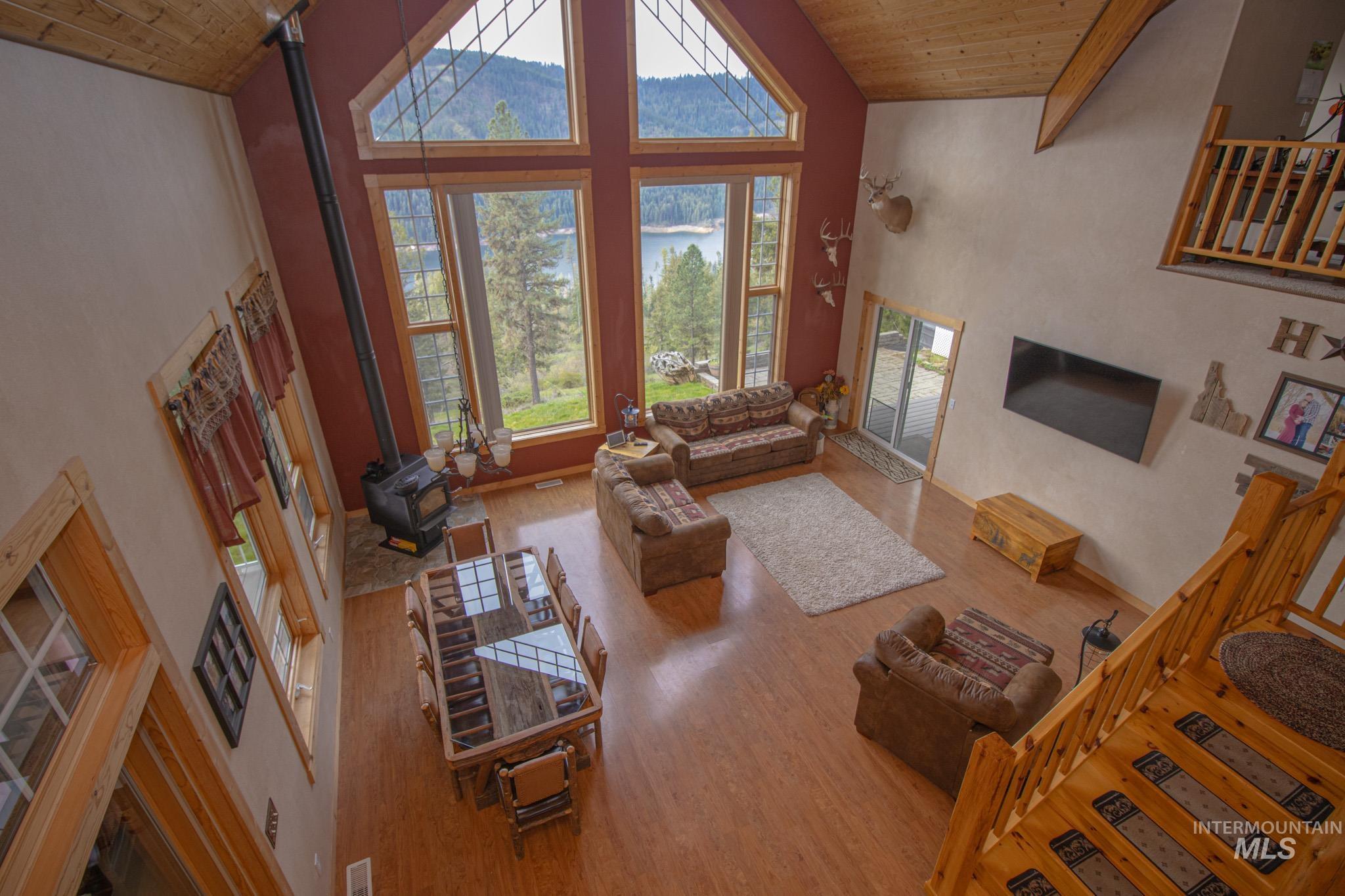 237 Old Dent Road Orofino, ID 83544 - Photo 7 of 48 Living room featuring a vaulted wood ceiling, a wood stove, and light wood-style flooring