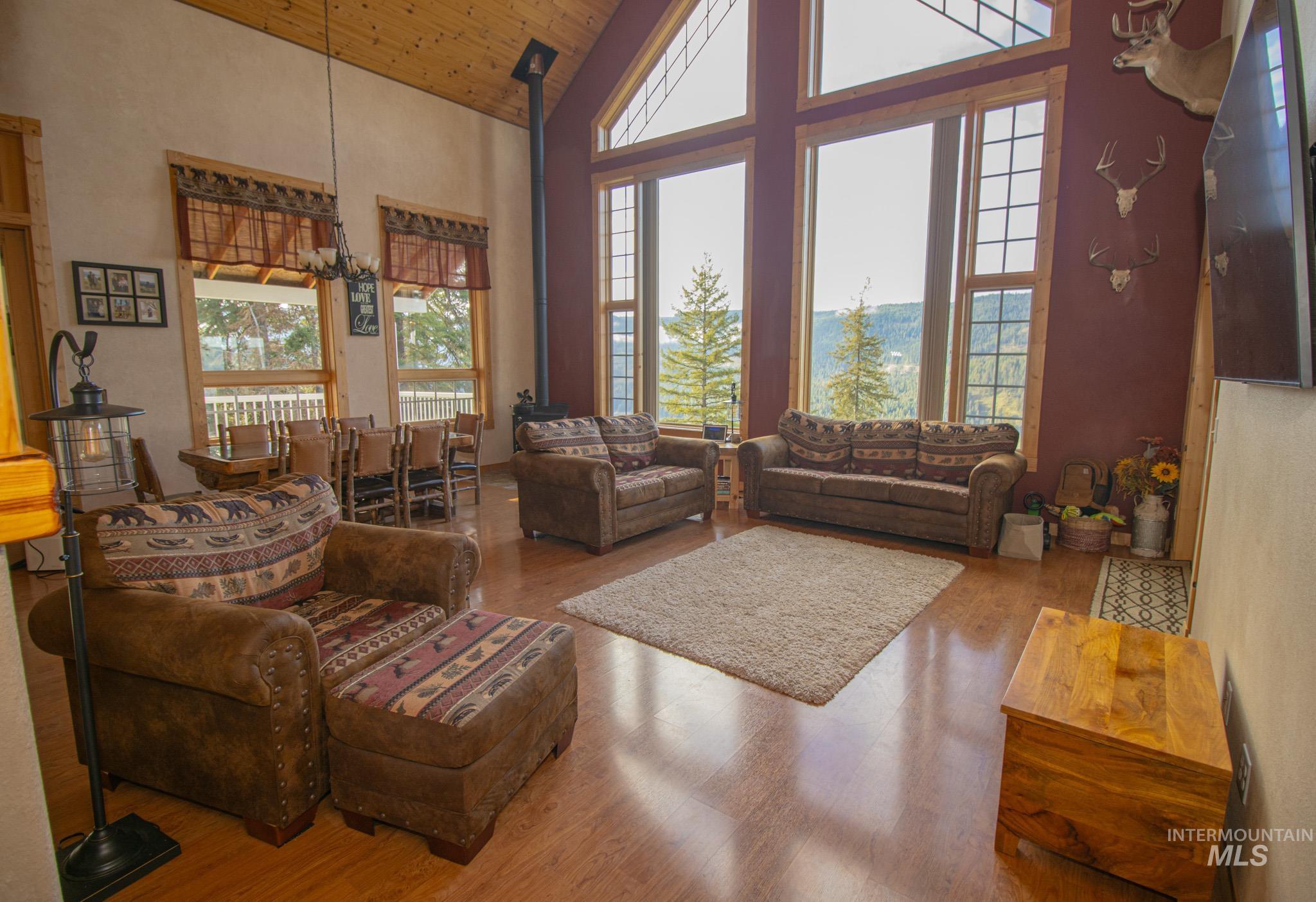 237 Old Dent Road Orofino, ID 83544 - Photo 8 of 48 Living room with a vaulted wooden ceiling, wood finished floors, a wood stove, and a chandelier