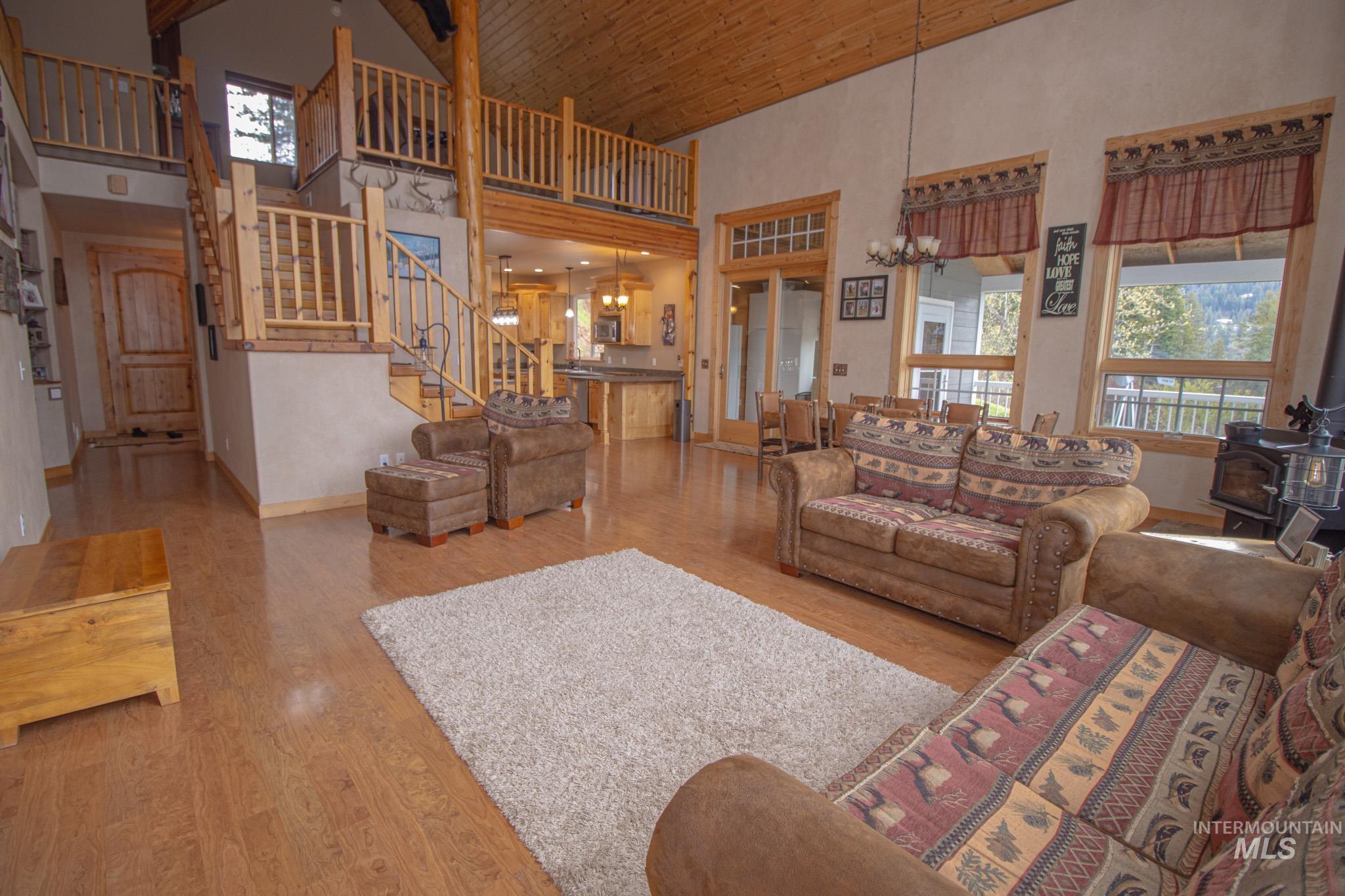 237 Old Dent Road Orofino, ID 83544 - Photo 9 of 48 Living room with suspended lighting, a wood stove, light wood-style floors, and a vaulted wooden ceiling