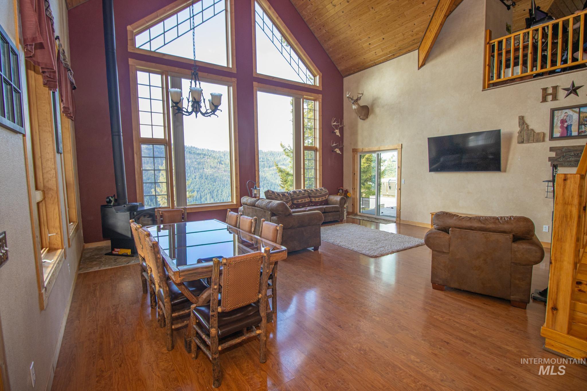 237 Old Dent Road Orofino, ID 83544 - Photo 10 of 48 Dining area featuring wood finished floors, a vaulted wood ceiling, hanging lights, and a wood stove