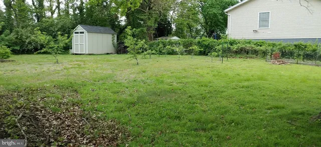 a view of a house with a backyard and trees