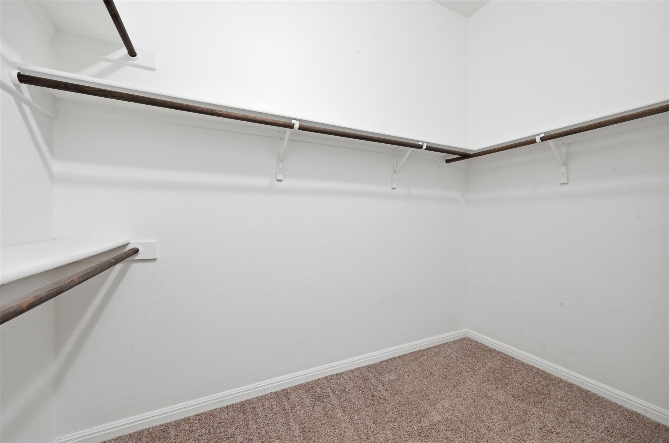 13116 Alans Way Manchaca, TX 78652 - Photo 15 of 25 Walk-in closet with ample storage, L-shaped shelving, and a neutral carpet