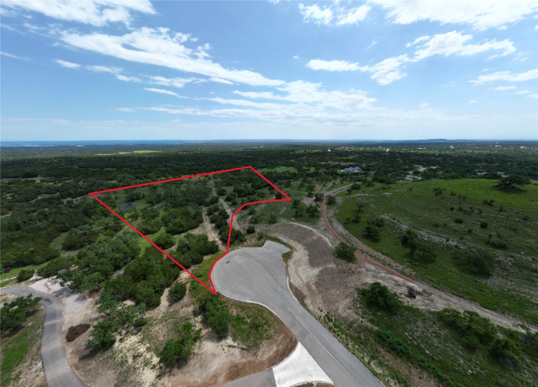 a view of a pathway both side of grassy field with shrub