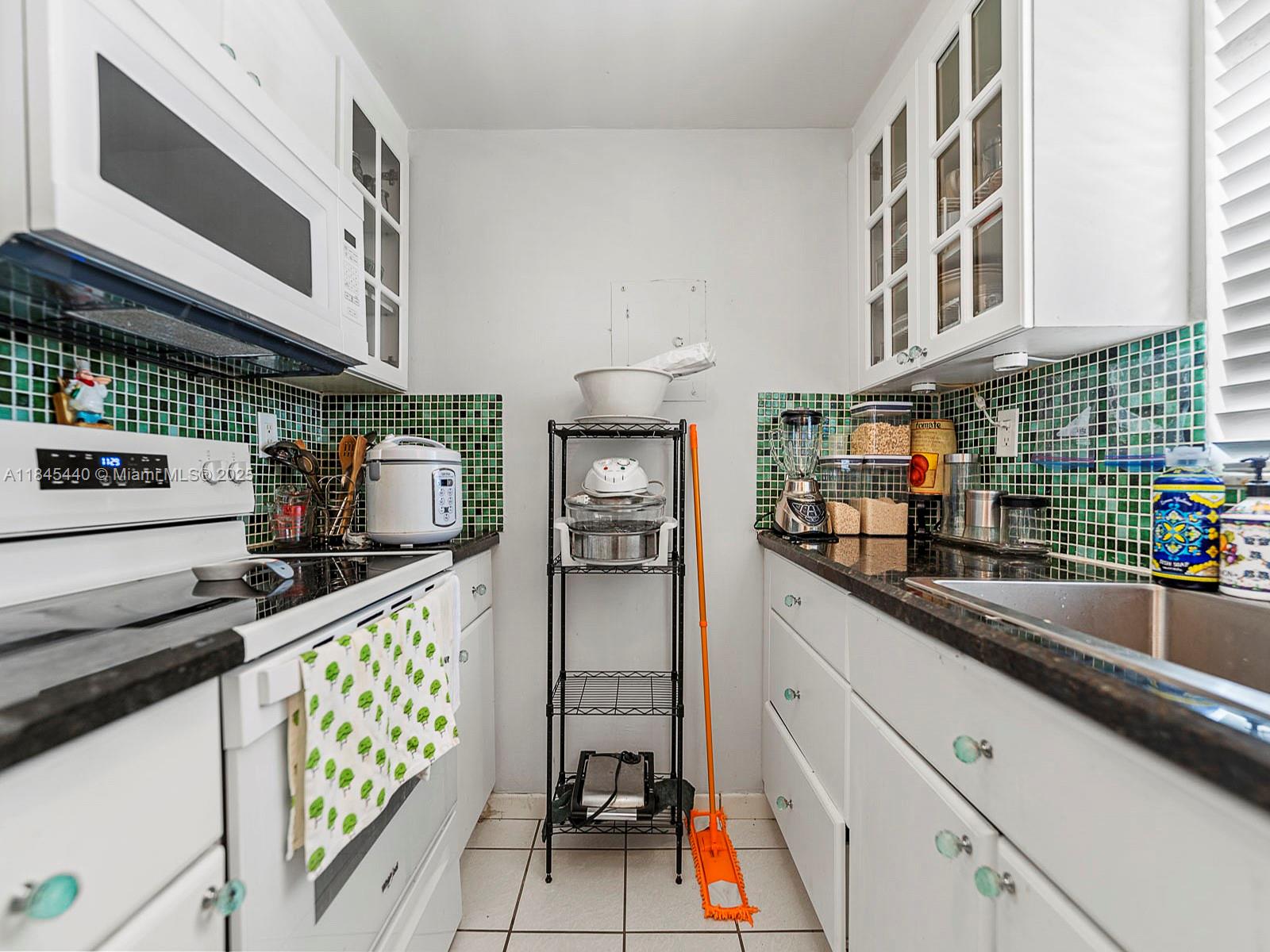 2690 Southwest 22nd Avenue, Unit 507 Miami, FL 33133 - Photo 3 of 20 a kitchen with stainless steel appliances a sink a stove and cabinets