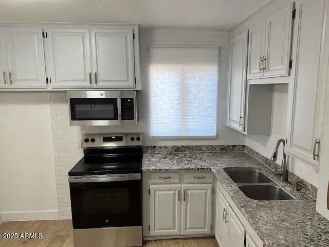 a kitchen with stainless steel appliances granite countertop a sink stove and microwave