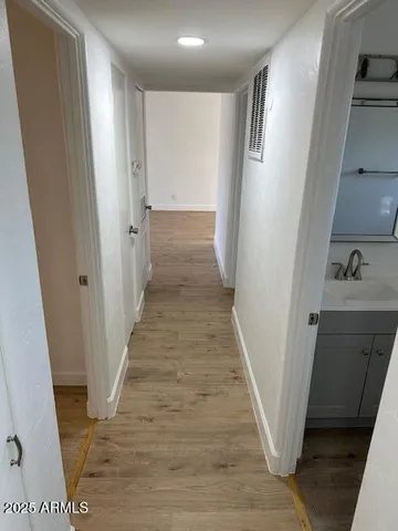a view of a hallway with wooden floor and staircase