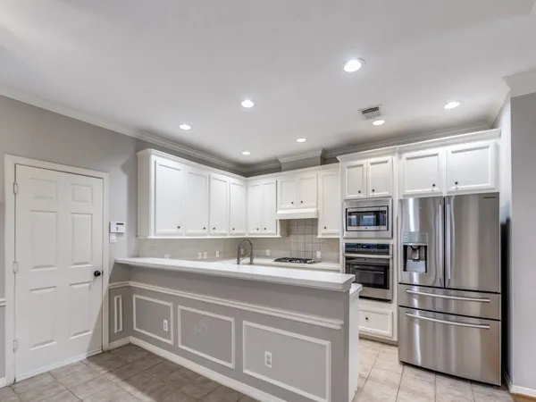 a kitchen with kitchen island a sink and white stainless steel appliances