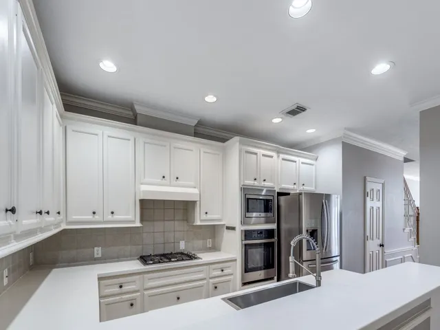 a kitchen with stainless steel appliances kitchen island granite countertop a stove and a refrigerator