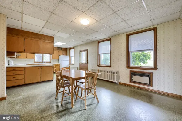 a view of an empty room with wooden floor and fence