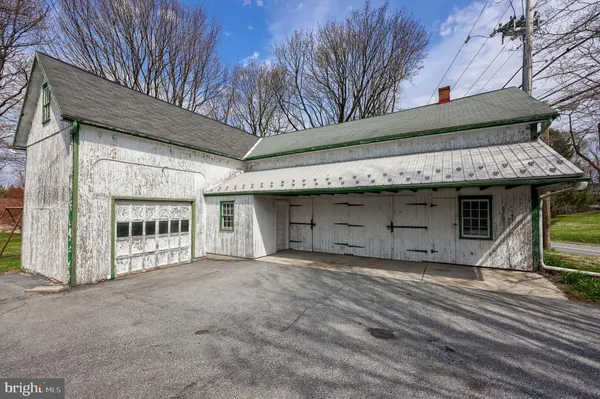 a dining hall with stainless steel appliances granite countertop a stove a sink dishwasher and cabinets with wooden floor