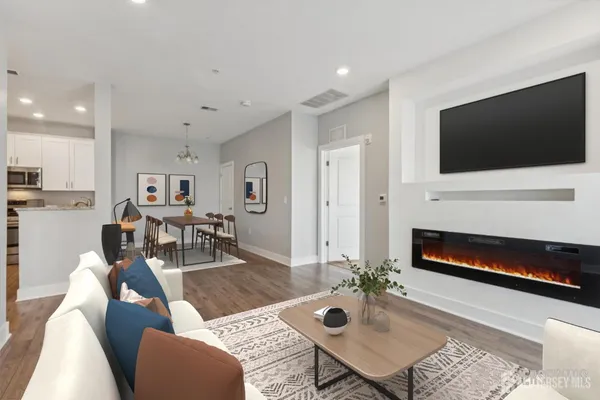 a living room with furniture a flat screen tv and a fireplace