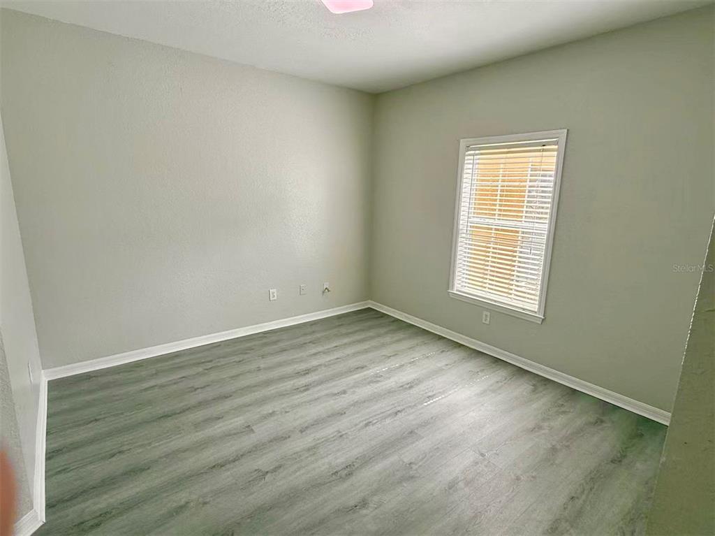 3751 Conroy Road, Unit 2334 Orlando, FL 32839 - Photo 6 of 20 an empty room with wooden floor and windows