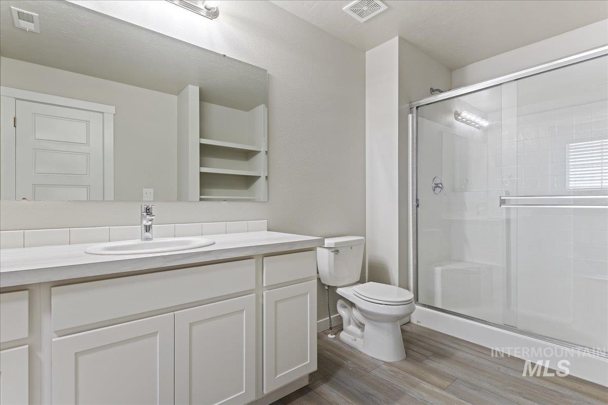2479 East Goldstone Street Meridian, ID 83642 - Photo 19 of 29 Bathroom featuring a shower stall, vanity, and light wood-type flooring
