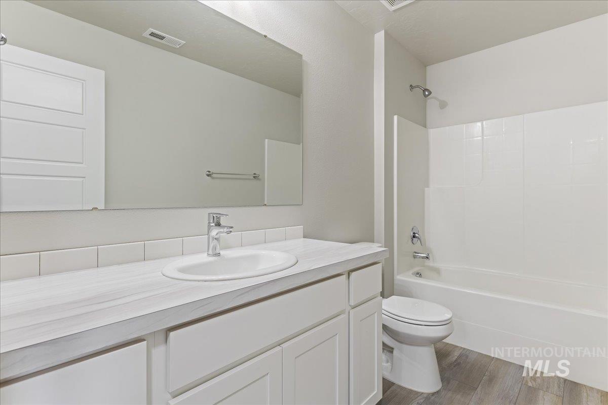 2479 East Goldstone Street Meridian, ID 83642 - Photo 21 of 29 Full bath featuring vanity, shower combination, and wood finished floors