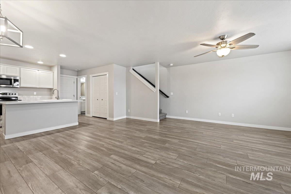 2479 East Goldstone Street Meridian, ID 83642 - Photo 4 of 29 Unfurnished living room featuring light wood-style floors, recessed lighting, and a ceiling fan