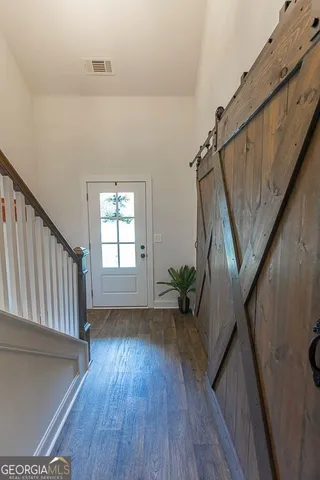 a kitchen with refrigerator and wooden floor