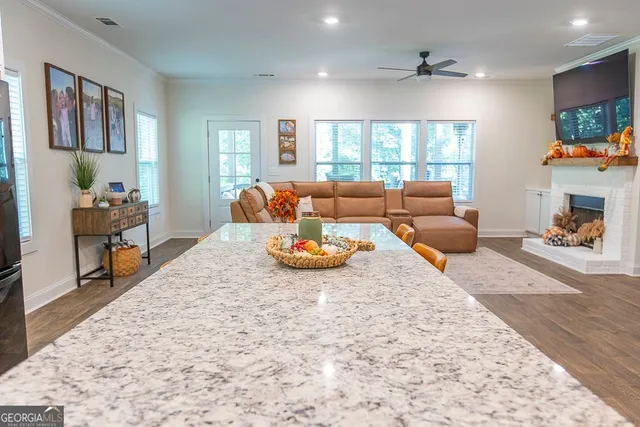 a kitchen with stainless steel appliances granite countertop sink refrigerator and wooden floor