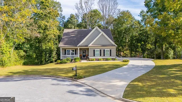 an aerial view of a house with swimming pool and large trees